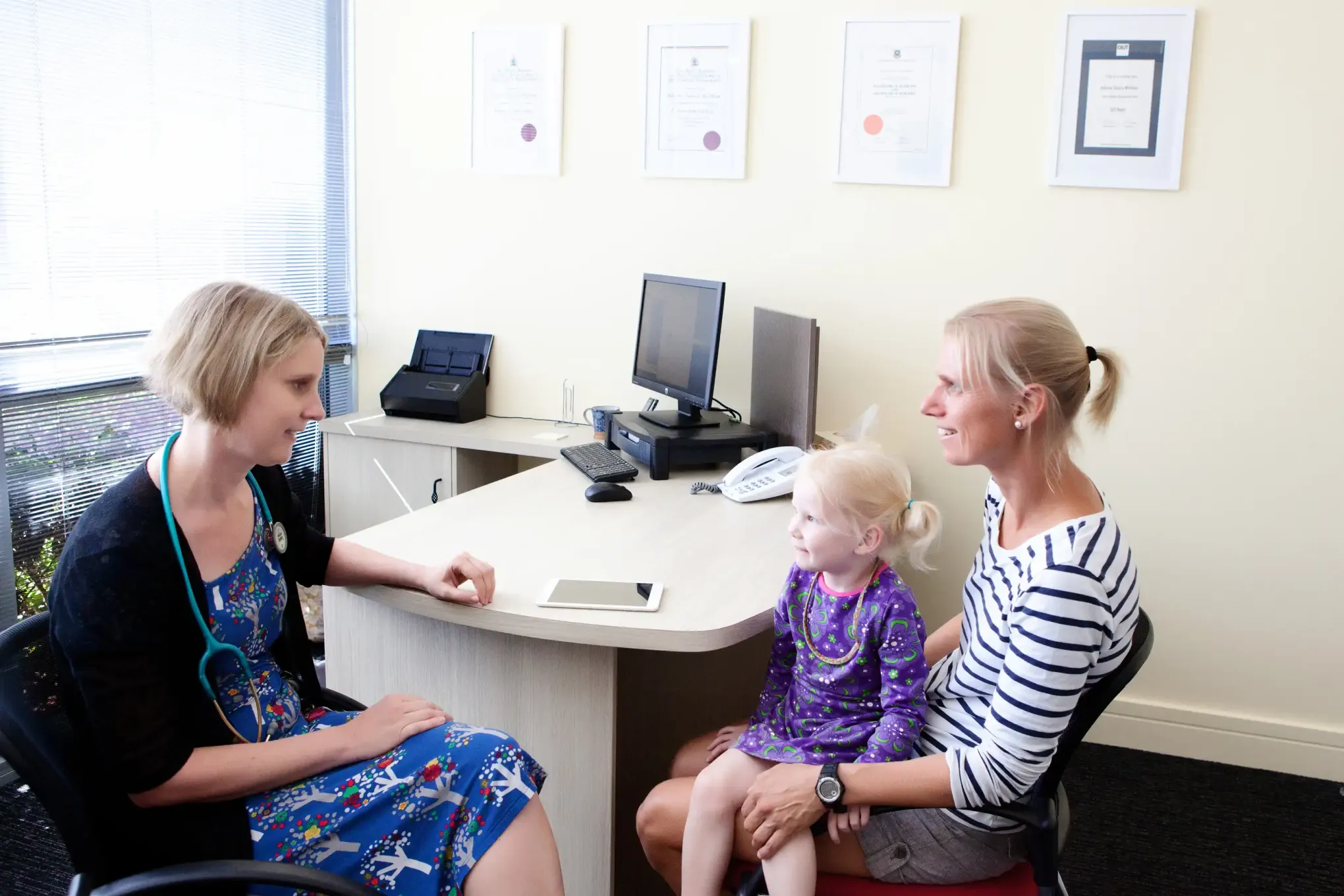 Dr. Wickham consulting with a patient and her toddler